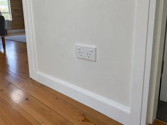 White double power point on a plain wall beside a timber floor and doorway in Narraweena